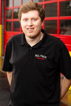 Smiling person in black All Tech Maintenance shirt.
