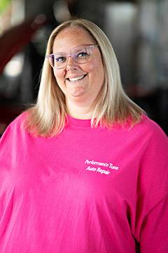 Smiling woman in pink auto repair shirt