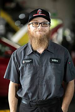 Auto mechanic in uniform inside workshop